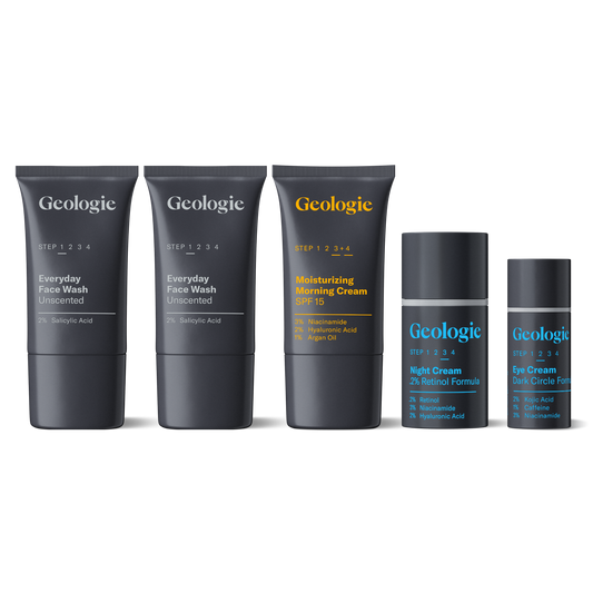 A set of four Geologie skincare products, including a salicylic acid face wash, everyday sunscreen, moisturizing cream, and eye cream, arranged against a dark background.